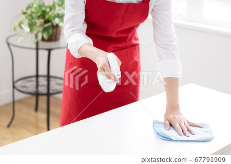 Housekeeping hand of a woman who sanitizes the table 67791909