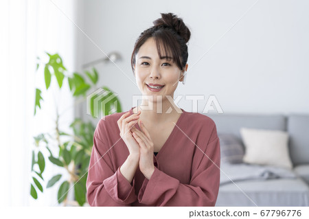 Young woman wearing wireless earphones and looking at camera Young woman wearing wireless earphones and looking at camera 67796776