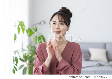 Young woman wearing wireless earphones and looking at camera Young woman wearing wireless earphones and looking at camera 67796778