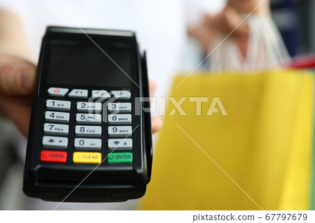 Man hold cash register close up on background of packages with purchases. 67797679