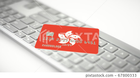 Plastic bank card depicting flag of Hong Kong on computer keyboard. Fictional numbers 67800333