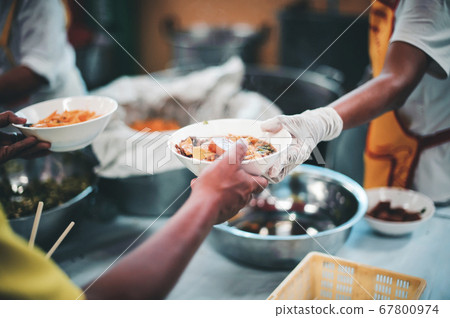 Volunteers give food to needy people, share food 67800974