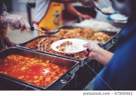 Volunteers give food to needy people, share food 67800981