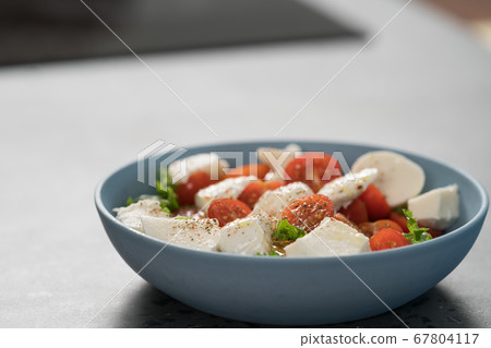 salad with mozzarella, tomatoes and lettuce in blue bowl salad with mozzarella, tomatoes and lettuce in blue bowl 67804117