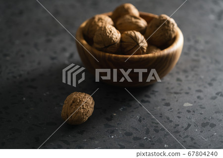 inshell walnuts in olive wood bowl on terrazzo countertop 67804240
