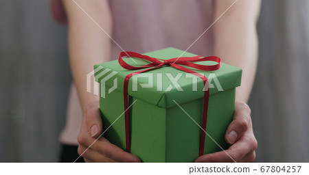 young woman stand and show green gift box with red ribbon bow young woman stand and show green gift box with red ribbon bow 67804257