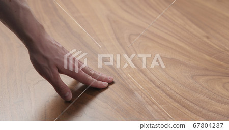 man hand touches black walnut dining table surface 67804287