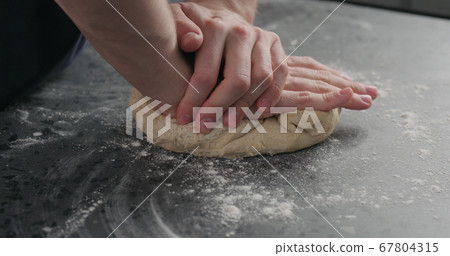 man working with dough on concrete countertop 67804315