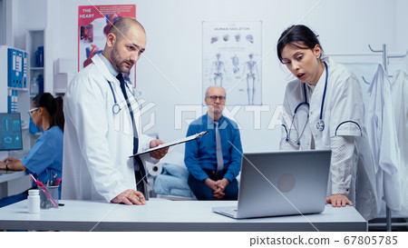Doctor team discussing elderly patient problem Doctor team discussing elderly patient problem 67805785
