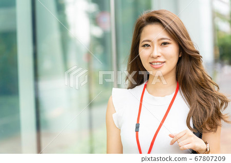 [Business scene] A young office lady with a smiling office district [Summer] 67807209