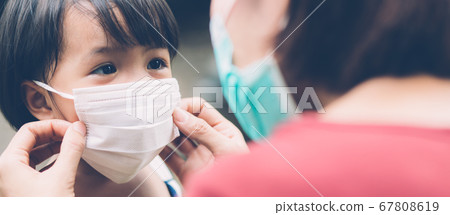 Mother take care daughter with face mask for protection disease flu or covid-19 outdoors. Mother take care daughter with face mask for protection disease flu or covid-19 outdoors. 67808619