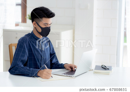 Young asian business man in face mask for protect covid-19 and work on laptop computer. Young asian business man in face mask for protect covid-19 and work on laptop computer. 67808631