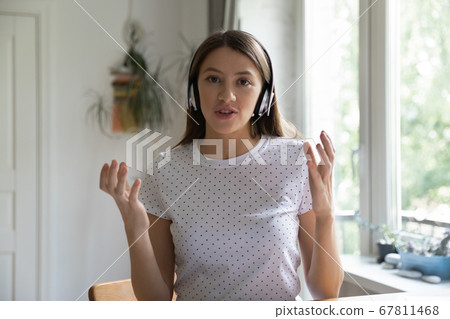 Young woman in headphones talk on video call 67811468
