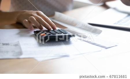 Close up of woman calculate managing household finances 67811681