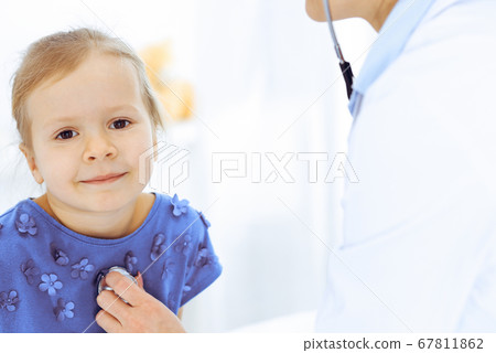 Doctor examining a little girl by stethoscope. Happy smiling child patient at usual medical inspection. Medicine and healthcare concepts Doctor examining a little girl by stethoscope. Happy smiling child patient at usual medical inspection. Medicine and healthcare concepts 67811862