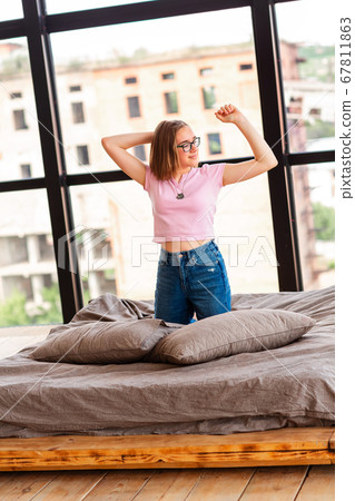 Cute teenage girl stretching on the bed in her Cute teenage girl stretching on the bed in her 67811863