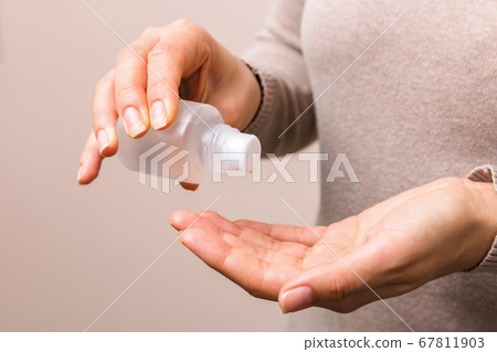 close up woman hands disinfecting hands indoors with hands sanitizer 67811903