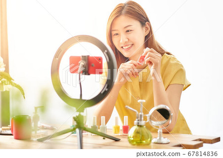 介紹在智能手機照相機前面的一個少婦化妝用品 介紹在智能手機照相機前面的一個少婦化妝用品 67814836