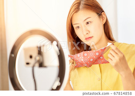 Young woman putting on a mask in front of the camera Young woman putting on a mask in front of the camera 67814858