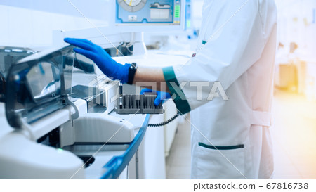 Laboratory assistant in rubber gloves working with Laboratory assistant in rubber gloves working with 67816738