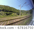 view from the window of a train car passing amidst summer nature with hills, mountains and forest. Vacation and travel concept. 67816750