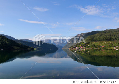 Norway Hardanger Fjord, Ulvik district, contrasting view of early morning mountains and water surface and spacious sky Norway Hardanger Fjord, Ulvik district, contrasting view of early morning mountains and water surface and spacious sky 67817547