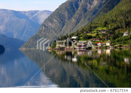 Norway Hardanger Fjord, Ulvik district, morning sunlit houses and early morning mountains and water views 67817554