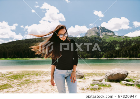 attractive woman relax in countryside with lake view on vacations attractive woman relax in countryside with lake view on vacations 67820947