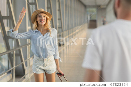 Man picking up his woman in the airport building Man picking up his woman in the airport building 67823534