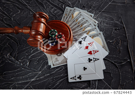Concept of legal regulation of gambling, justice gavel on the background of an old grey table Concept of legal regulation of gambling, justice gavel on the background of an old grey table 67824443