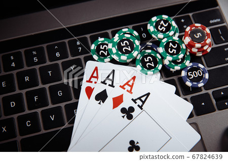 Online casino concept. Gambling chips and playing cards on laptop keyboard Online casino concept. Gambling chips and playing cards on laptop keyboard 67824639