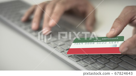 Man pays online with plastic bank card with printed flag of Hungary. Fictional numbers 67824643