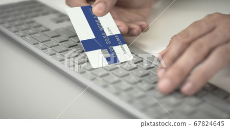 Man pays online with plastic bank card with printed flag of Finland. Fictional numbers Man pays online with plastic bank card with printed flag of Finland. Fictional numbers 67824645