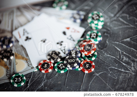 Poker cards and stacks of poker chips on a grey background. Poker online concept Poker cards and stacks of poker chips on a grey background. Poker online concept 67824978