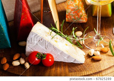 Cheese of elite variety sliced on a wooden board 67825289