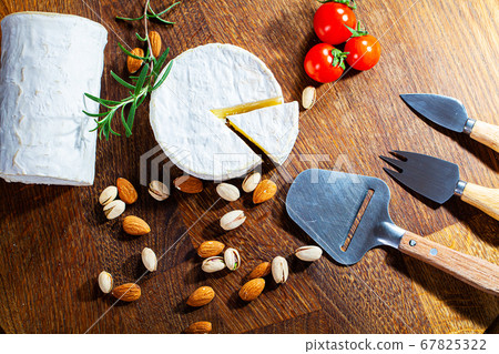 Cheese of elite variety sliced on a wooden board 67825322