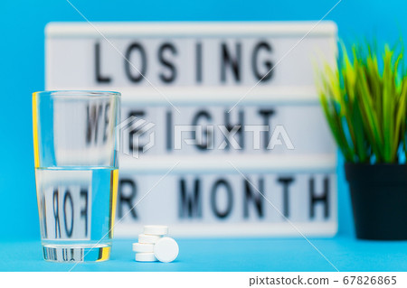 White weight loss pills on blue background 67826865