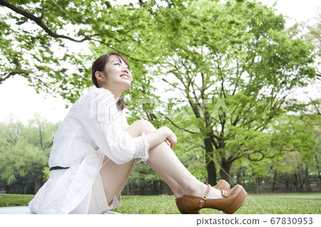 A woman sitting on the lawn A woman sitting on the lawn 67830953