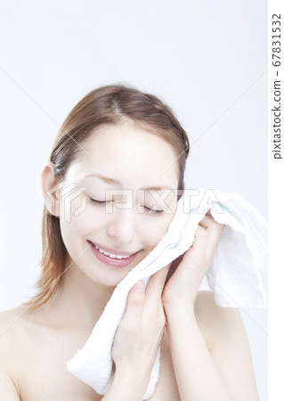 A woman wiping his face with a towel 67831532