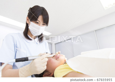 Girl treating teeth 67835955