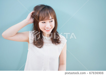 Woman in front of a blue wall 67836908