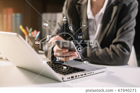 Businesswomen hand using smart phone, tablet payments online shopping, omni channel, digital tablet docking keyboard computer at office in sun light. 67840271