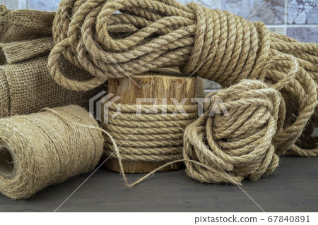 Jute rope and spools of burlap threads or twine 67840891