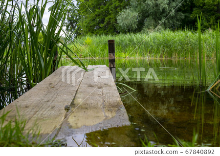 Old rustic wooden jetty on a tranquil lake 67840892