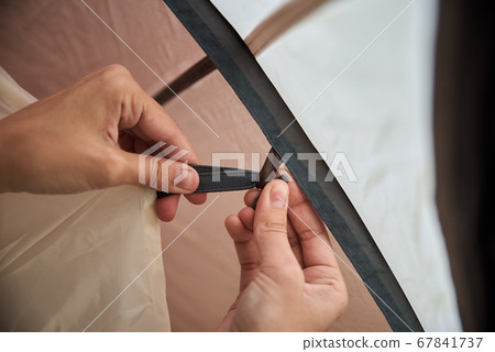 Woman setting up camping tent at the forest 67841737