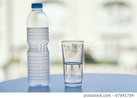 Bottle of water and glass of water on table in hot 67841784