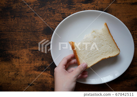 拿麵包的手,餐具和桌子 拿麵包的手,餐具和桌子 67842511