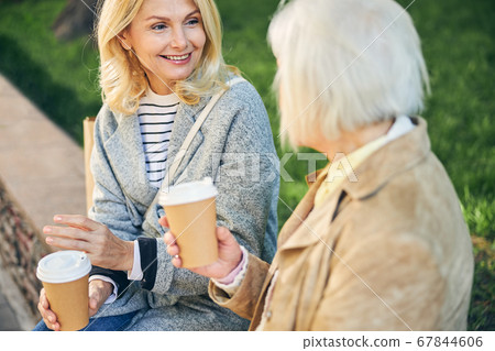 Smiling woman looking to her friend in the park 67844606