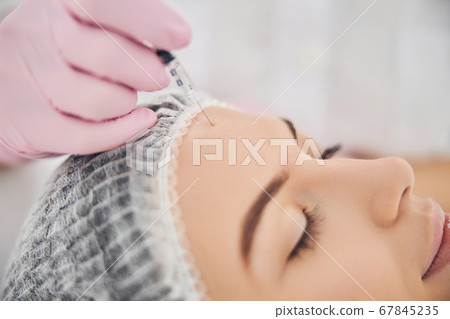 Face lifting procedure handled by skillful cosmetologist 67845235