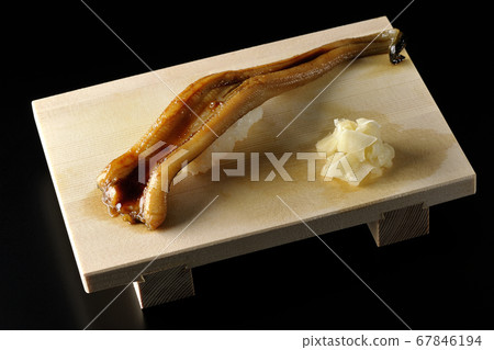 A handful of conger eel on a sushi stand (black background) A handful of conger eel on a sushi stand (black background) 67846194